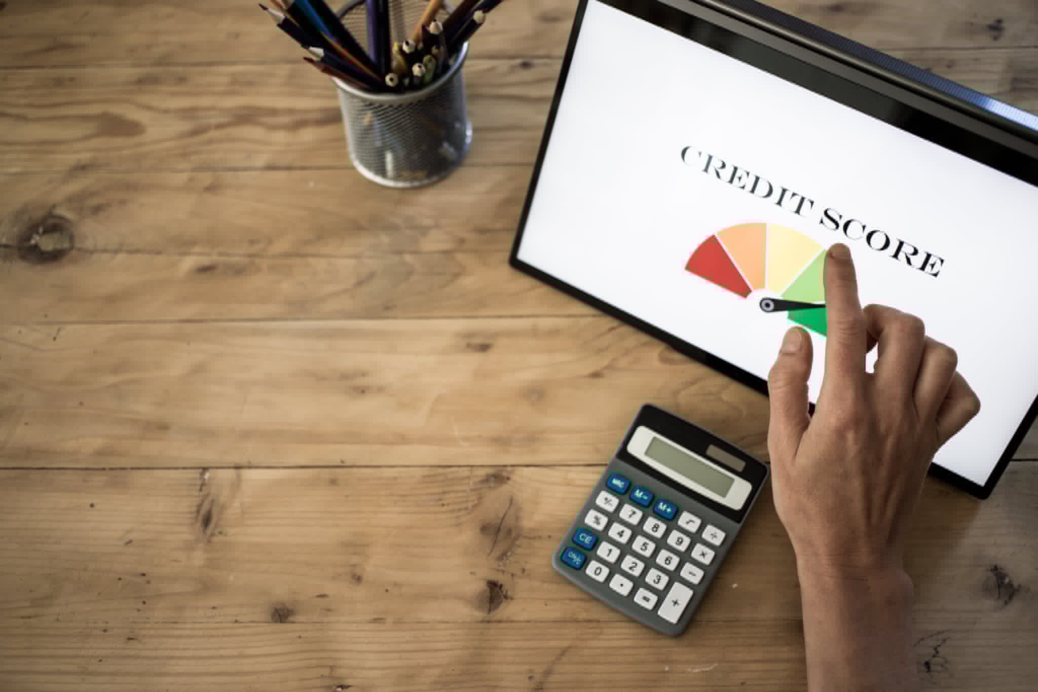 online-finances-hand-pressing-credit-score-button-on-tablet